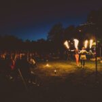 Gespannte Zuschauer bei einer Feuershow bei SOMMERJUNG, dem Ferienlager für Erwachsene